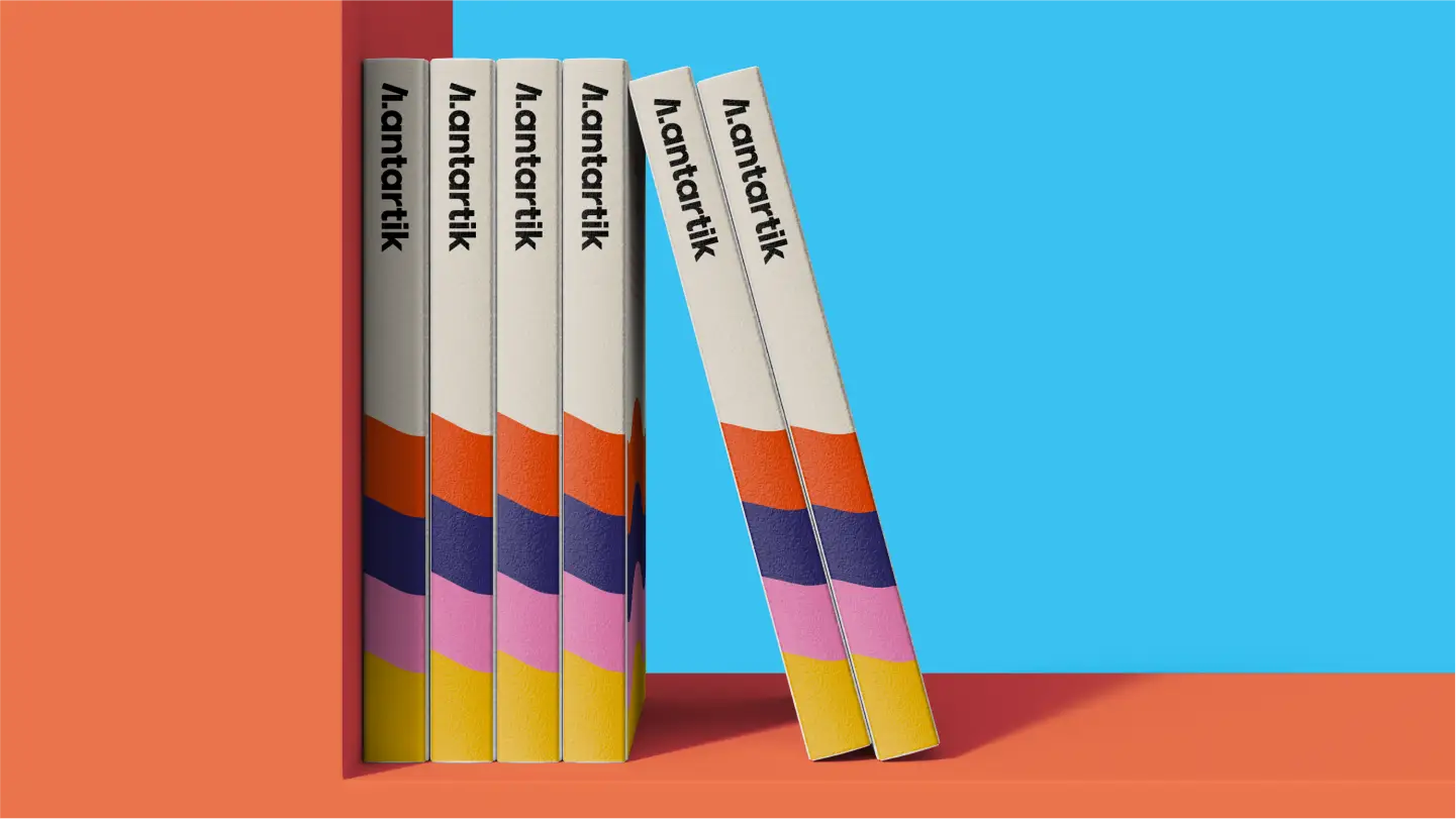 A stack of books sitting on top of a table, with Antartik written on it