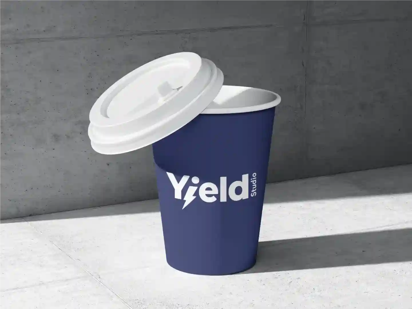 A coffee cup with Yield logo sitting on the ground.